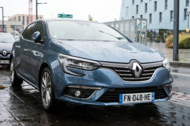 Mulhouse - Fransa - 30 Ağustos 2020 - Yağmurlu bir günde sokağa park edilmiş mavi Renault Megane manzarası