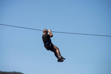 Kruth - Fransa - 9 Eylül 2020 - İnsan portresi mavi gökyüzü arka planında bir halatla iniyor