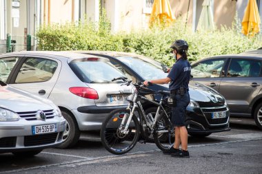 Mulhouse - Fransa - 11 Eylül 2020 - VTT 'li kadın polisin sokaktaki park halindeki arabaları kontrol etmesi
