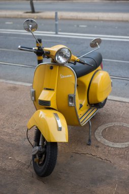 Lizbon - Portekiz - 29 Eylül 2020 - Sokakta park edilmiş sarı renkli vespa scooter manzarası