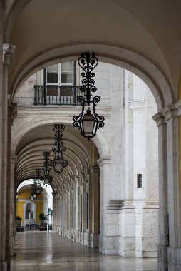 Lizbon Portekiz 'deki ticaret meydanı koridorunda klasik sokak lambalarının hizalanma görüntüsü