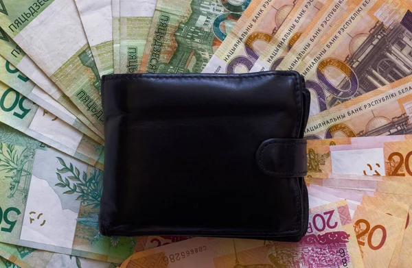Belarus Rublesi 'nin arka planında cüzdan ve Belarus rublesi desenli banknotlar var.