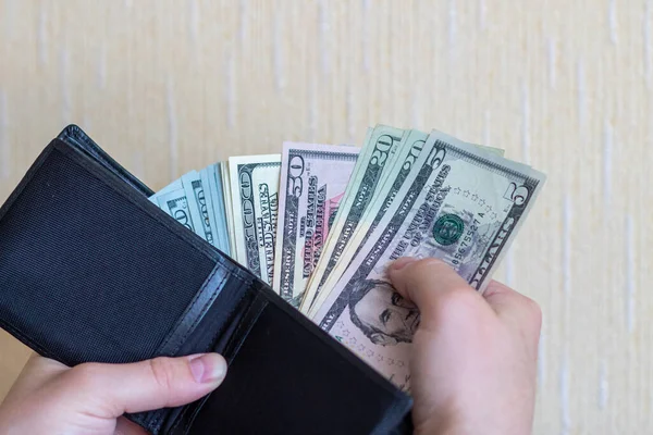 Dolarla öde. Cüzdanından dolarları çıkar. Beyaz arka planda cüzdanı olan dolar banknotları.