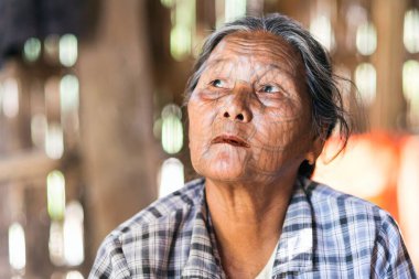 MRAUK U, RAKHINE Eyaleti / MYANMAR - 7 Aralık 2015: Yüzünde Myanmar Asia dövmesi olan yaşlı bir Chin kadınının portresi