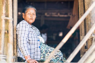 MRAUK U, RAKHINE Eyaleti / MYANMAR - 7 Aralık 2015: Yüzünde Myanmar Asia dövmesi olan yaşlı bir Chin kadınının portresi