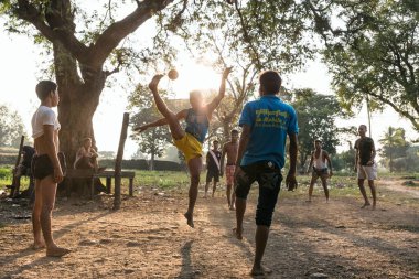 MRAUK U, RAKHINE Eyaleti / MYANMAR - 6 Aralık 2015: Myanmar Asia caddelerinde milli sporda chinlone oynayan Burmalı gençler