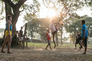 MRAUK U, RAKHINE Eyaleti / MYANMAR - 6 Aralık 2015: Myanmar Asia caddelerinde milli sporda chinlone oynayan Burmalı gençler