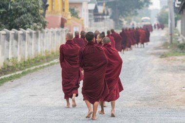 Keşişler sabahın erken saatlerinde Myanmar Burma Asya 'da çıplak ayakla dolaşıyorlar.