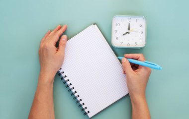 Kadınların elleri liste yapmak için ya da yeşil arkaplanda planlar yapmak için yazarlar. Üst görünüm, boşluk kopyala.