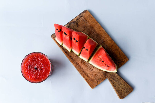 Watermelon Sliced on a Cutting Board with Watermelon Juice on a Grey Background