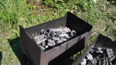 Barbekü kullanıma hazır. Kömürler sıcak ve dumanlıdır.