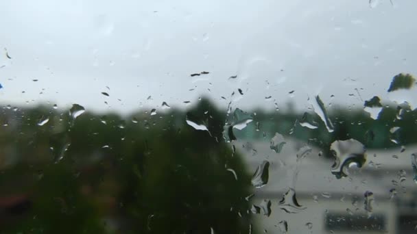 Капли Дождя Стекают Стеклу Стеклом Идет Дождь Видны Расплывчатые Силуэты — стоковое видео