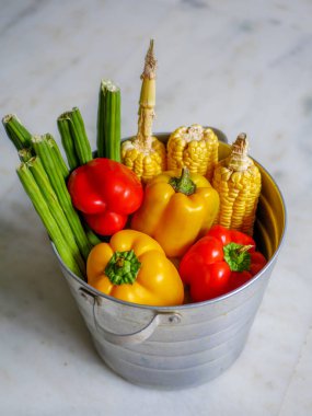 Beyaz arka planda izole edilmiş taze sağlıklı organik sebzelerle dolu sepet.