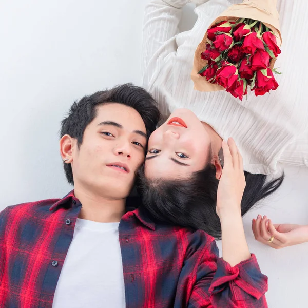 Mutlu genç çiftin üstte kameraya bakıp yerde yatarken gülümsediği görülüyor