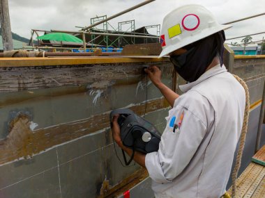 The inspectors are checking defect in welded at butt joint with process Ultrasonic testing (UT) of Non-Destructive Testing (NDT) at industrial factory.