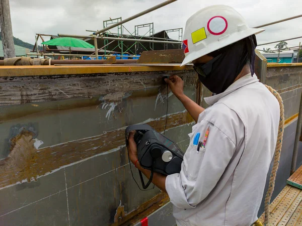 The inspectors are checking defect in welded at butt joint with process Ultrasonic testing (UT) of Non-Destructive Testing (NDT) at industrial factory.