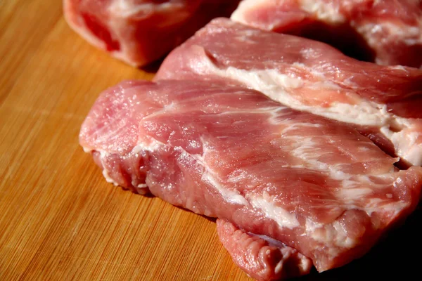 Kesme tahtasında çiğ domuz pirzolası.