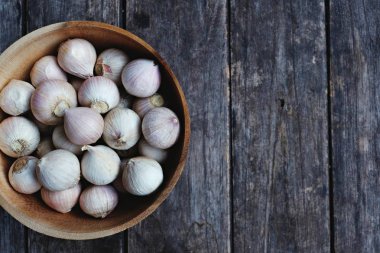 Ahşap masa arka plan, kopya alanı, gıda kavramı üzerinde ahşap kase taze sarımsak üstten görünüm