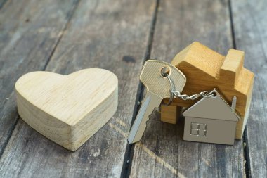 Ev Anahtarlık ve ahşap kalp vintage ahşap arka plan üzerinde ev tatlı ev concept alay etmek yukarıya ile ev anahtarı