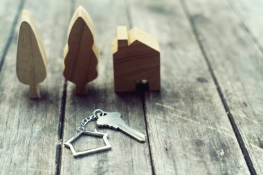 Ev Anahtarlık ve ahşap ağaç ve ev mockup vintage ahşap arka plan, mülkiyet kavramı üzerinde ev anahtarı