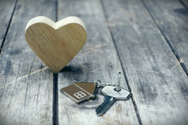 Ev Anahtarlık ve ahşap kalp vintage ahşap arka plan, ev tatlı ev concept, kopya alanı üzerinde sahte kadar ev anahtarı