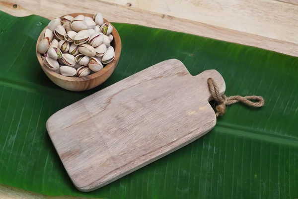 Gesalzene Pistazien Holzschale Auf Holztisch Mit Grünem Bananenblatt Hintergrund Kopierraum — Stockfoto