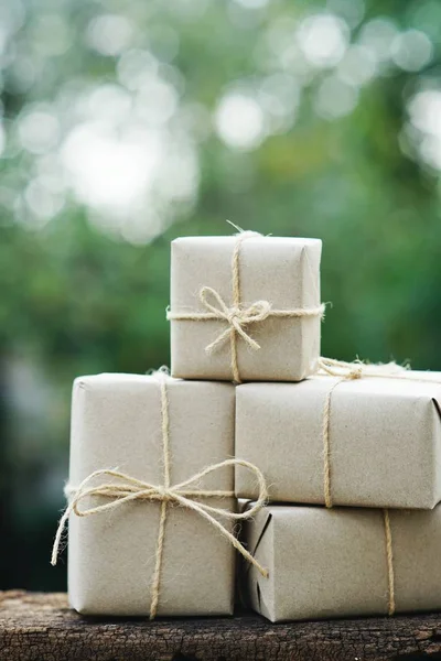 Simple eco friendly gift boxes package wrap with brown paper on vintage wooden table, green present concept, copy space