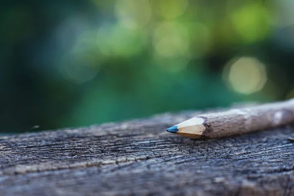 手工铅笔由木头制成的木桌上以光滑的绿色庭院背景 — 图库照片