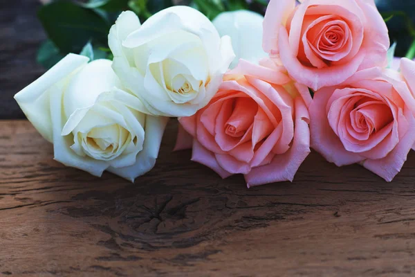 Beautiful white and pink fresh rose flower and mini heart on wooden background, soft tone valentine concept, copy space