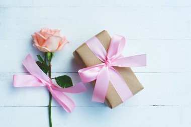 Pembe kurdele ve kahverengi hediye kutusu beyaz ahşap masa arka plan üzerinde bağlı güzel yumuşak turuncu pembe renk gül, tatlı Sevgililer sunmak kavram, kopya alanı
