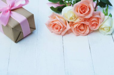 Pembe kurdele ve kahverengi hediye kutusu beyaz ahşap masa arka plan üzerinde bağlı güzel yumuşak turuncu pembe renk gül, tatlı Sevgililer sunmak kavram, kopya alanı