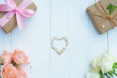 Pembe kurdele ve kahverengi hediye kutusu beyaz ahşap masa arka plan üzerinde bağlı güzel yumuşak turuncu pembe ve beyaz renk gül, tatlı Sevgililer sunmak kavram, kopya alanı