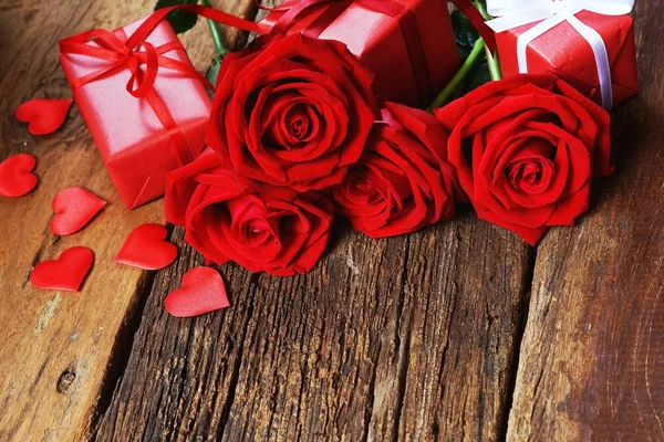集团可爱的绽放红色玫瑰花在木桌背景上装饰与迷你红色的心形和优雅的礼品盒 甜蜜的情人节礼物概念 复制空间 — 图库照片
