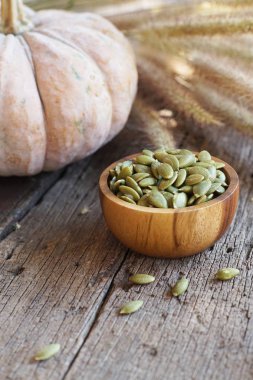 Kabak çekirdeği ve klasik ahşap masa arka plan, kopya alanı üzerinde ahşap kase taze kabak meyve