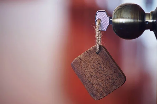 家庭钥匙与木制空白房子钥匙扣在钥匙孔 财产概念 复制空间 — 图库照片