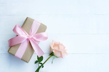 Pembe kurdele ve kahverengi hediye kutusu beyaz ahşap masa arka plan üzerinde bağlı güzel yumuşak turuncu pembe renk gül, tatlı Sevgililer sunmak kavram, kopya alanı