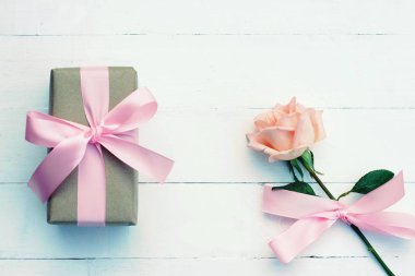 Pembe kurdele ve kahverengi hediye kutusu beyaz ahşap masa arka plan üzerinde bağlı güzel yumuşak turuncu pembe renk gül, tatlı Sevgililer sunmak kavram, kopya alanı