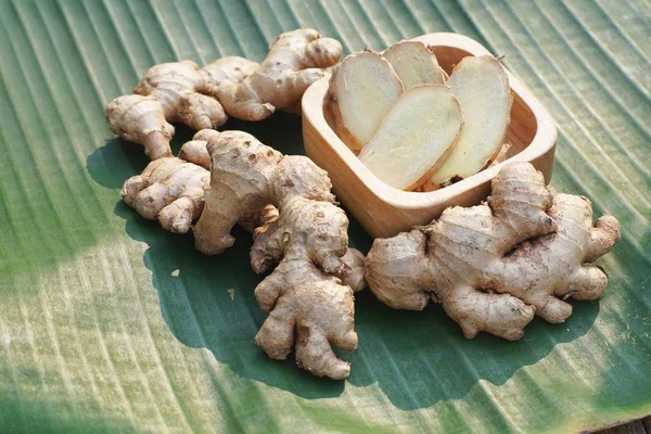 Frische Ingwerwurzel Und Ingwer Scheiben Geschnitten Auf Grünem Blatt Hintergrund — Stockfoto