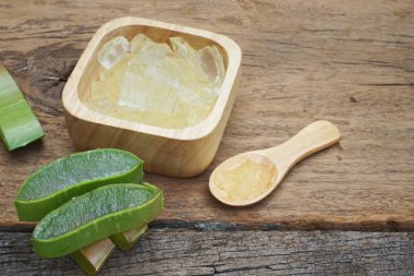 Taze aloe vera bitki, dilimleri ve jel ahşap arka plan, deri tedavisi kavramı, tarih alanı Kopyala