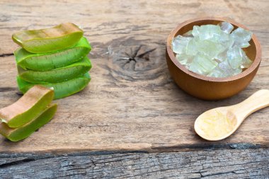 Taze aloe vera bitki, kök dilimleri ve jel ahşap arka plan, deri tedavisi kavramı, kopya alanı