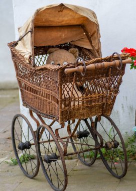 Oyuncak ayılı eski model hasır bebek arabası. Antika hasır bebek arabası..