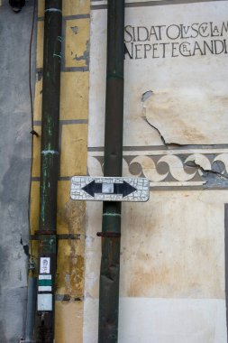 Duvardaki yön işareti sağı ve solu gösteriyor. Sağı ve solu gösteren siyah oklar..