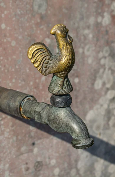 Vintage faucet with rooster.Bronze Water tap with rooster outside on the wall.