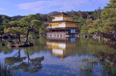 Bahçede altınla kaplanmış meşhur, çarpıcı, eski bir Japon tapınağı. Sonbahar arkaplanı.