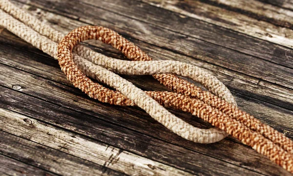 Corde legate in piedi su sfondo di legno. Illustrazione 3D — Foto Stock