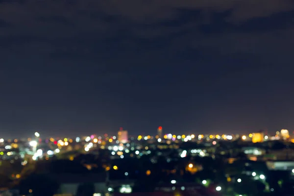 Πόλη τη νύχτα με σκοτεινό ουρανό, αφηρημένη θολούρα bokeh ανοιχτό φόντο — Φωτογραφία Αρχείου