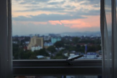 oda dışında şehir görünümünde gün batımı gökyüzü ile cam pencere