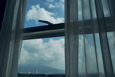 oda dışında mavi gökyüzü üzerinde bulut ile cam pencere