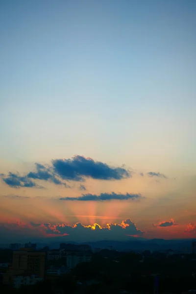 Световые лучи солнца на закате неба над городом — стоковое фото