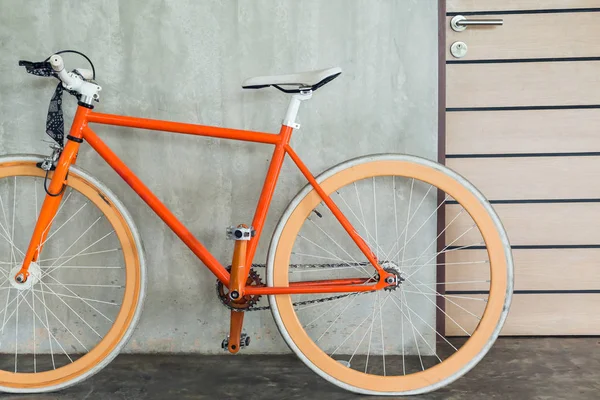 Bicicleta laranja estacionada decorar interior sala de estar estilo moderno — Fotografia de Stock